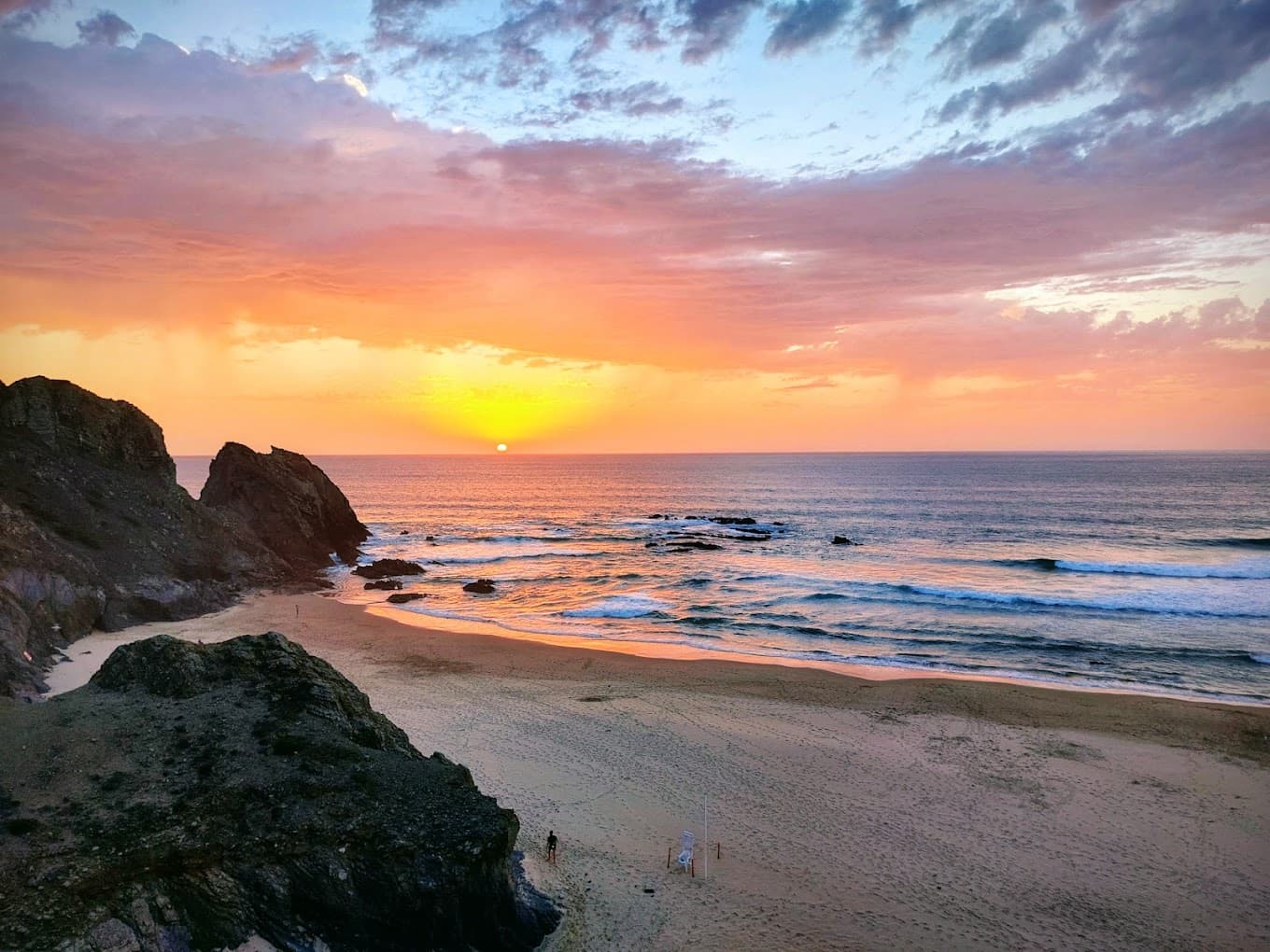 Praia de Vale dos Homens ao pôr do sol, com os rochedos e o mar em maré vaza