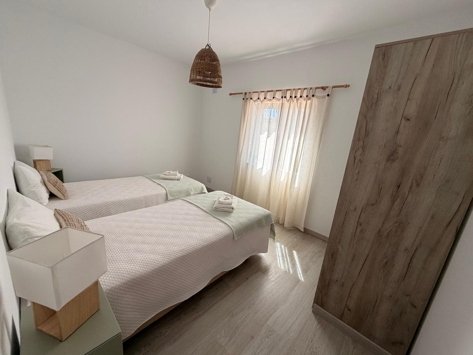 Quarto com duas camas individuais e cortinado de linho