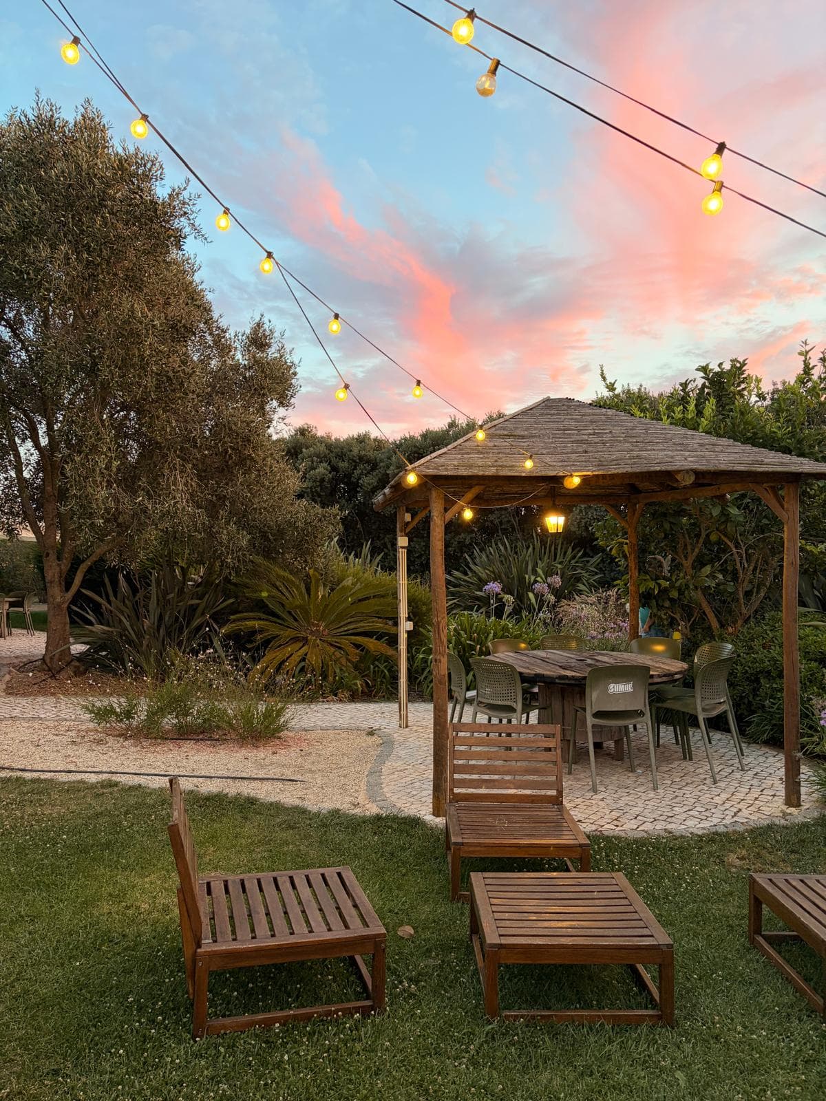 Gazebo do jardim ao entardecer, com luzes acesas