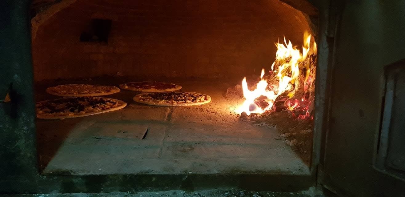 Interior do forno de lenha do Museu da Batata Doce com pão a cozer