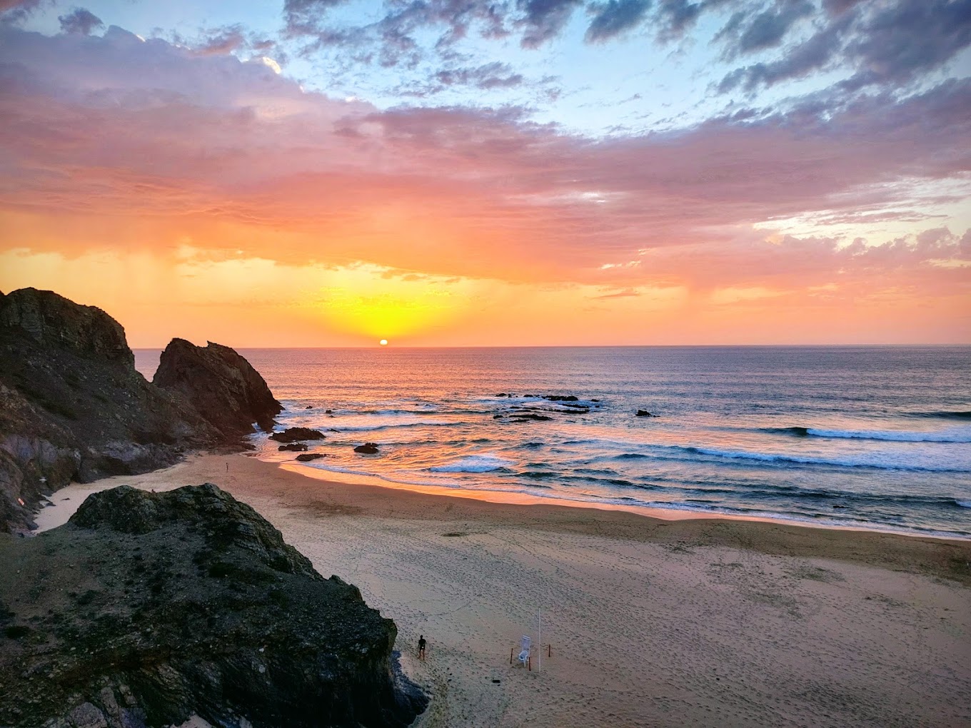 Praia de Vale dos Homens ao pôr do sol, com os rochedos e o mar em maré vaza