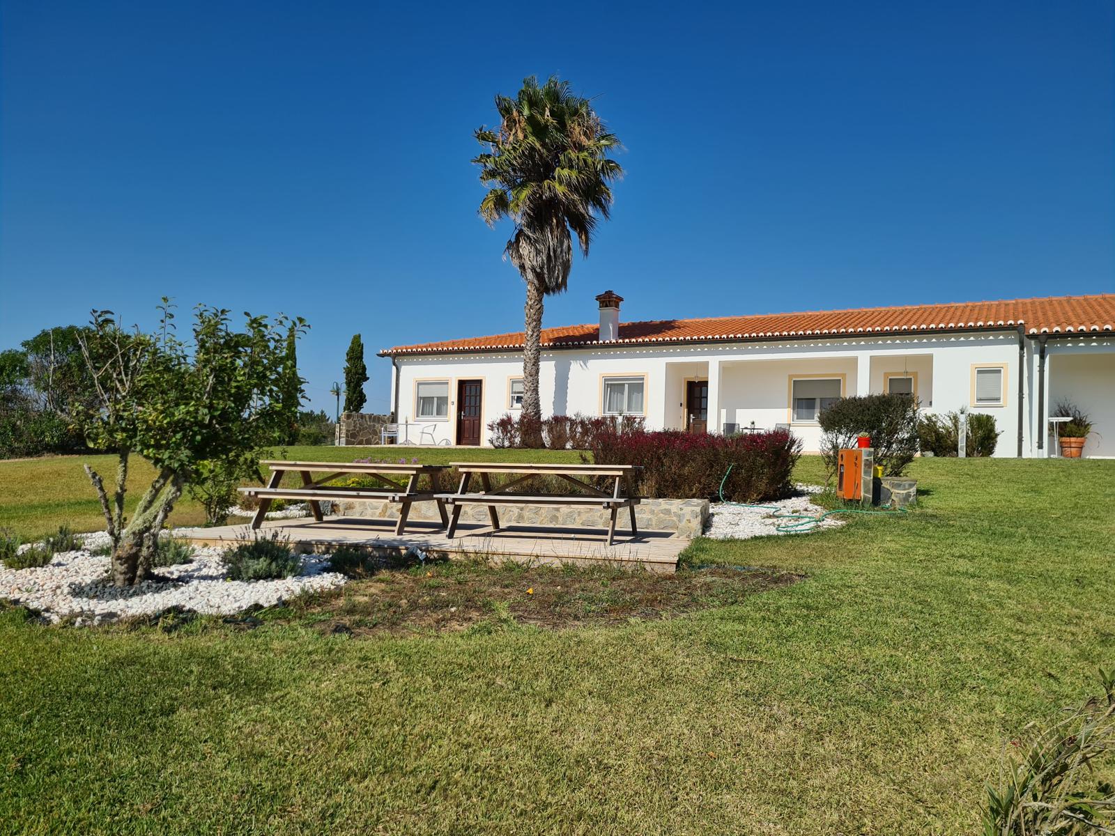 Sala de estar de uma das casas, com parede de cortiça e sofá