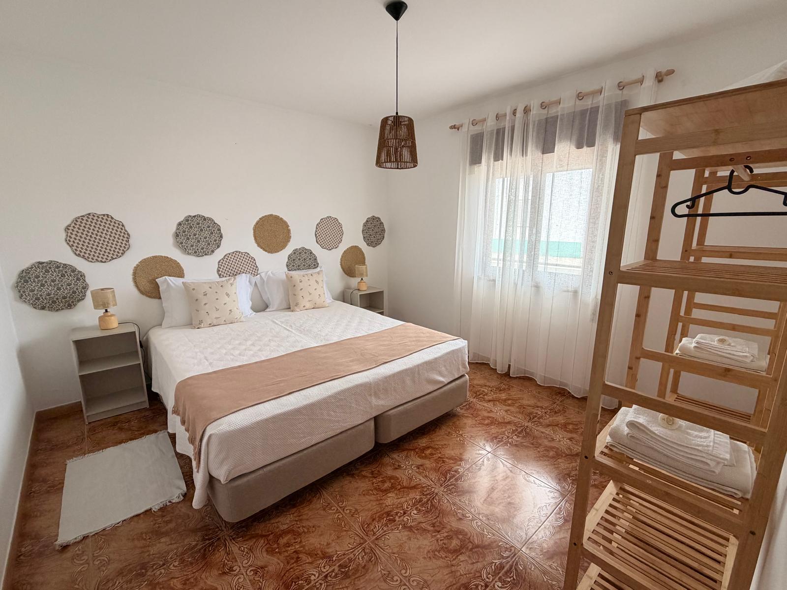 Quarto de casal, com cabeceira de pratos na parede
