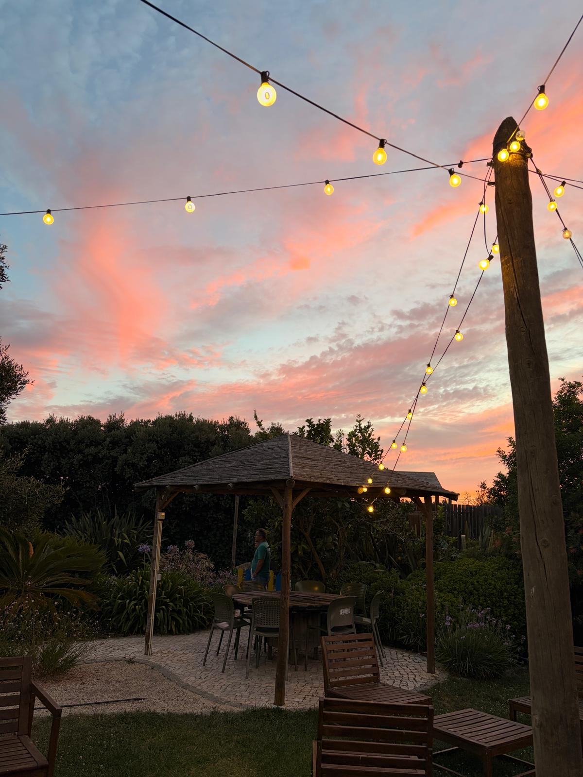Gazebo do Museu da Batata Doce ao pôr-do-sol, com luzes de festão acesas