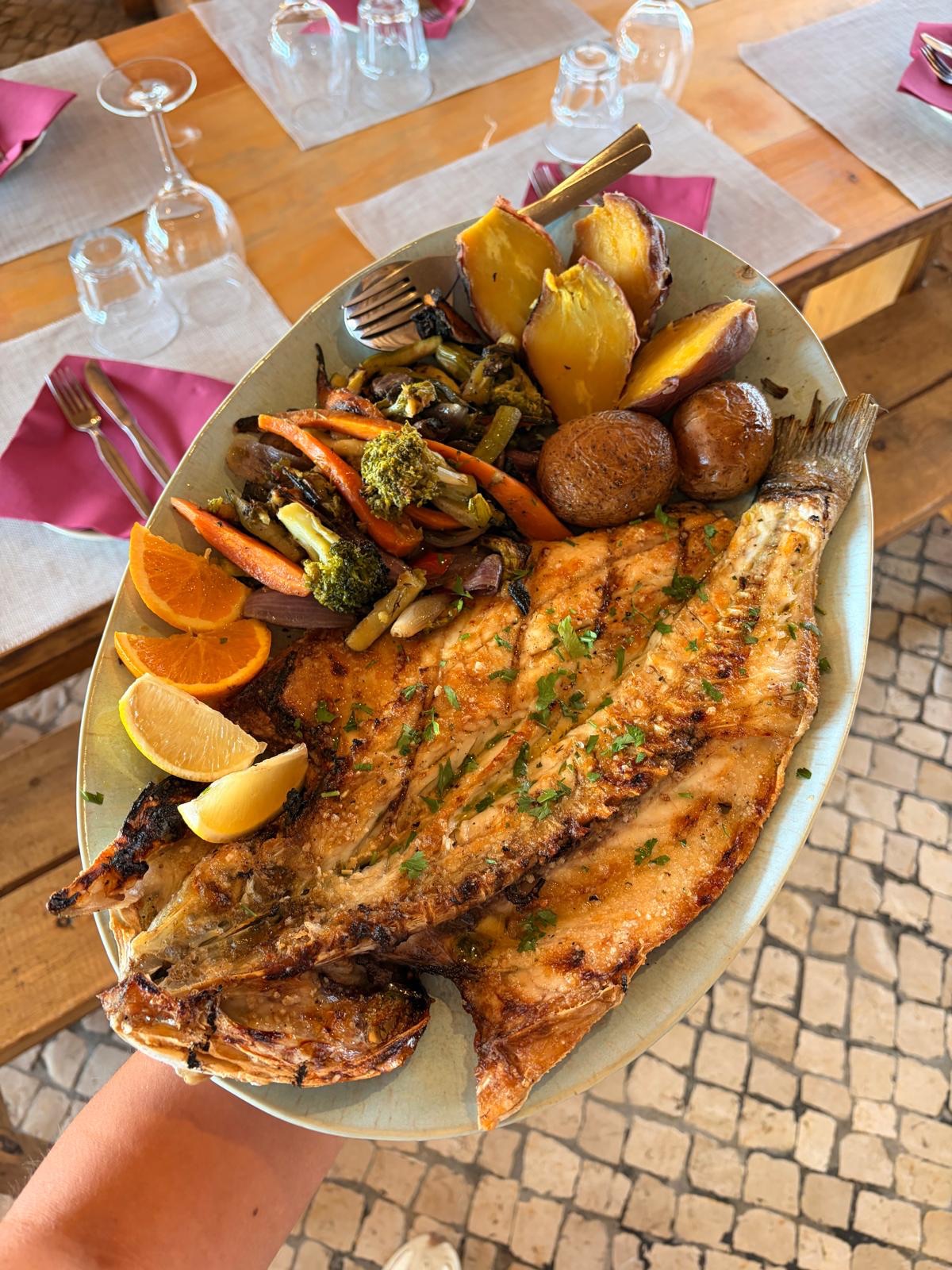 Peixe grelhado no carvão, servido com batata-doce assada e legumes